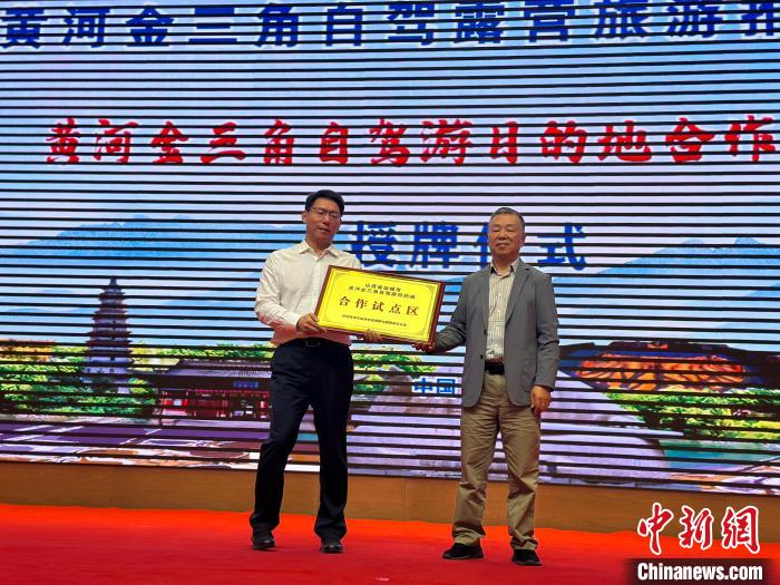 中國(guó)旅游車船協(xié)會(huì)自駕游與露營(yíng)房車分會(huì)向運(yùn)城市授牌“黃河金三角自駕游目的地合作試點(diǎn)區(qū)”。　劉小紅 攝