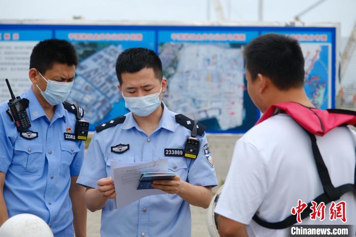 平潭邊檢站移民管理警察對船員證件進(jìn)行查驗(yàn)?！±钭谒?攝