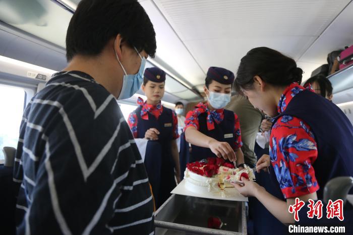 乘務(wù)員與旅客分享生日蛋糕。　周曉陽 攝