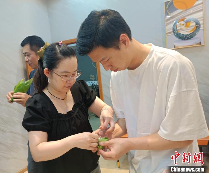圖為臺青吳攸在學(xué)習(xí)包粽子?！∏褫W軻 攝