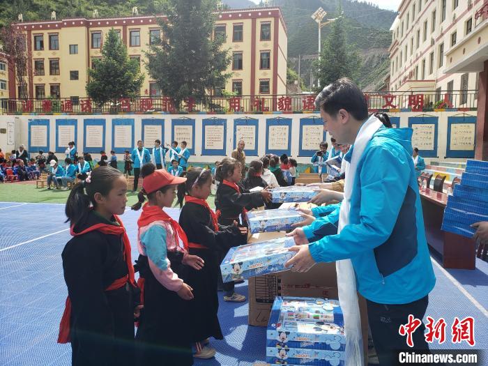 圖為公司員工代表給甘南州迭部縣多兒鄉(xiāng)中心小學(xué)的孩子們分發(fā)文具用品。(資料圖) 馬建斌 攝