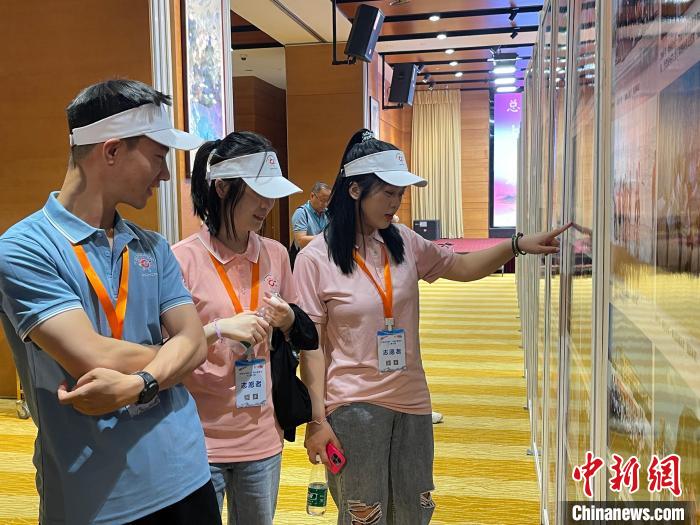 圖為夏令營志愿者參觀展覽?！≈熨R 攝