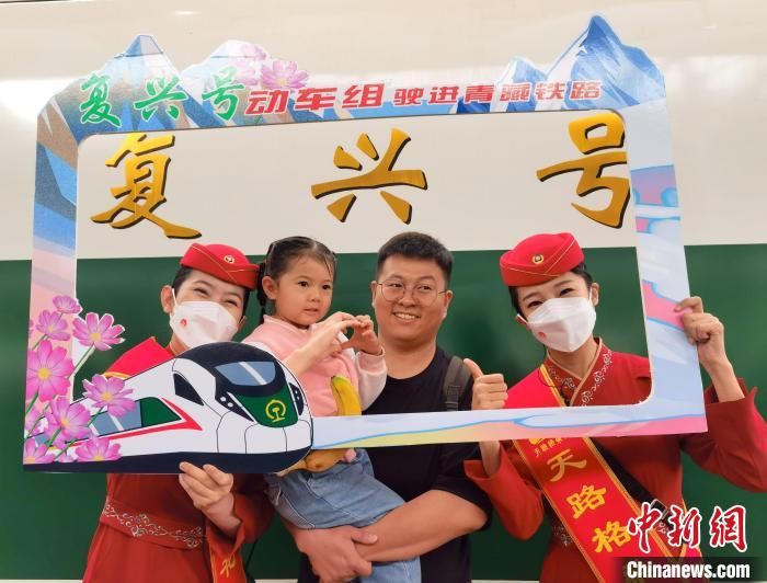7月1日，旅客在西寧車站與“復(fù)興號(hào)”紀(jì)念牌合影留念。中新社記者 祁增蓓 攝