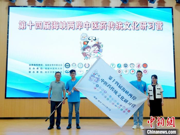 共青團(tuán)福建省委副書(shū)記吳雪(右一)、福建中醫(yī)藥大學(xué)黨委副書(shū)記林羽(左一)為兩岸學(xué)生代表頒授營(yíng)旗?！≡S燁婷 攝