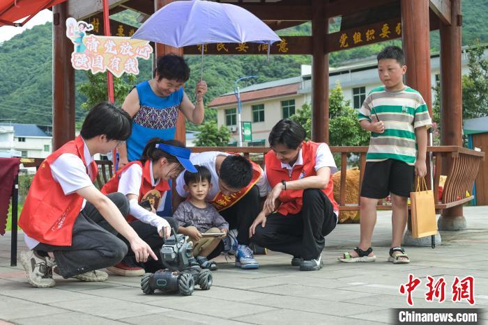 圖為學(xué)子們指導(dǎo)小朋友使用機器人。　陳一鳴 攝