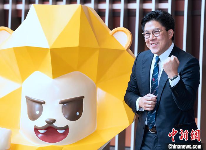 7月5日，香港立法會議員等在立法會綜合大樓為即將出征杭州2022年第19屆亞運會的中國香港代表團加油打氣。圖為立法會議員、中國香港體育協(xié)會暨奧委會副會長、本屆亞運會中國香港代表團團長霍啟剛在代表團吉祥物獅子“堅仔”旁為運動員加油。 <a target='_blank' href='/'>中新社</a>記者 侯宇 攝