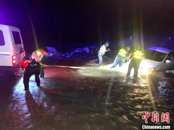 圖為民警幫助車輛安裝救援繩?！埩?攝