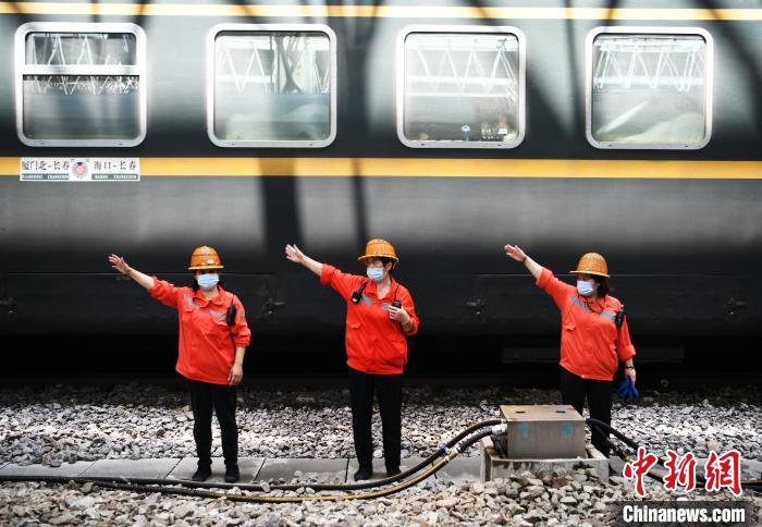 7月6日，在南昌車站，為到達(dá)的列車加滿清水后，上水工胡飛英和工友們比劃手勢(shì)準(zhǔn)備通過(guò)軌道上站臺(tái)?！『鷩?guó)林 攝