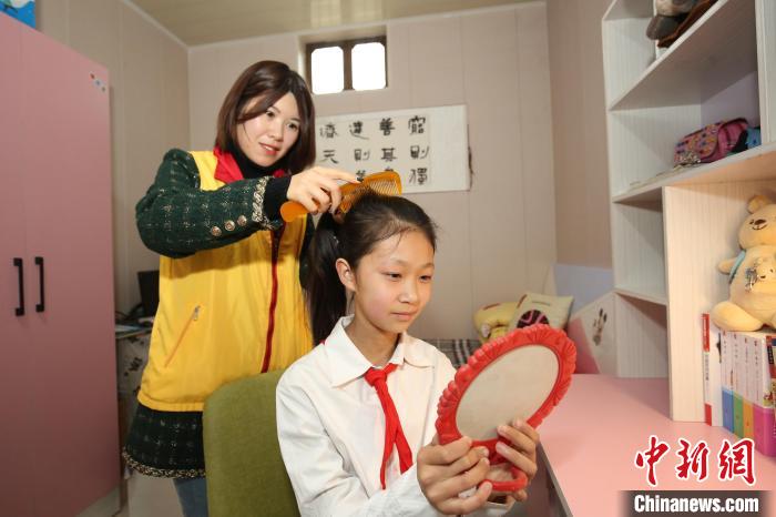 鄒城市“希望小屋”愛心媽媽志愿服務隊志愿者為兒童扎辮子?！⊥跹├?攝