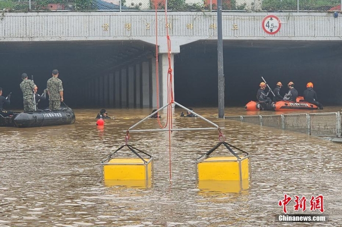 韓國(guó)救援人員沿著一條被洪水淹沒(méi)的道路搜尋失蹤人員，這條道路通往被洪水淹沒(méi)的地下隧道。視覺(jué)中國(guó)
