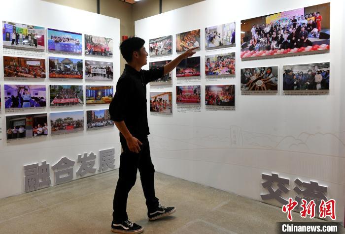 來自臺灣桃園的“80后”音樂人張家豪正在參觀圖片展?！蚊?攝