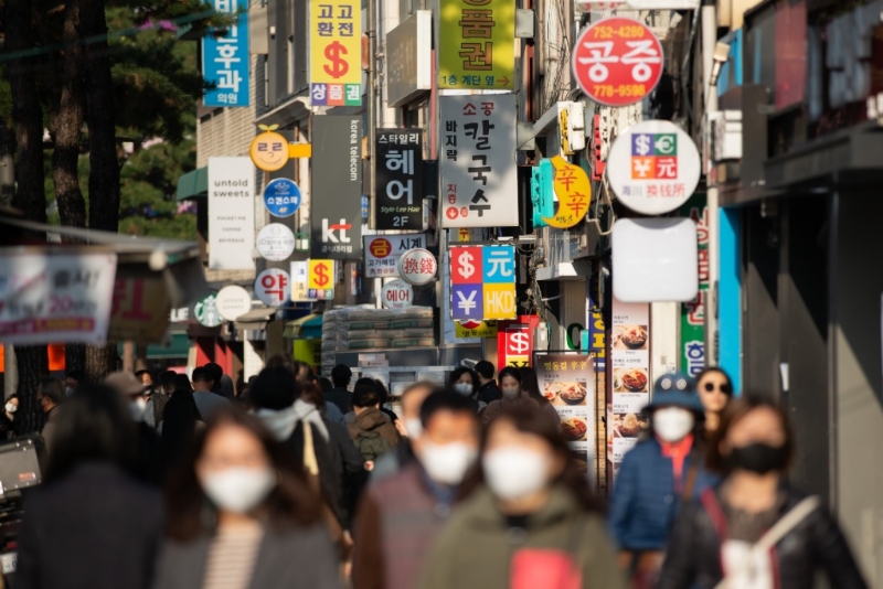 2022年11月24日，行人經(jīng)過韓國首爾明洞街區(qū)開設(shè)的一些換錢所。（圖源：新華社）
