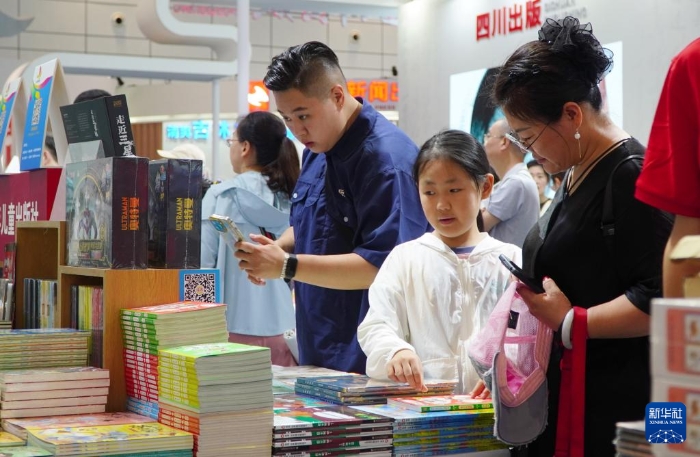 7月27日，在第31屆全國圖書交易博覽會上，讀者在閱覽新書。新華社記者 徐速繪 攝