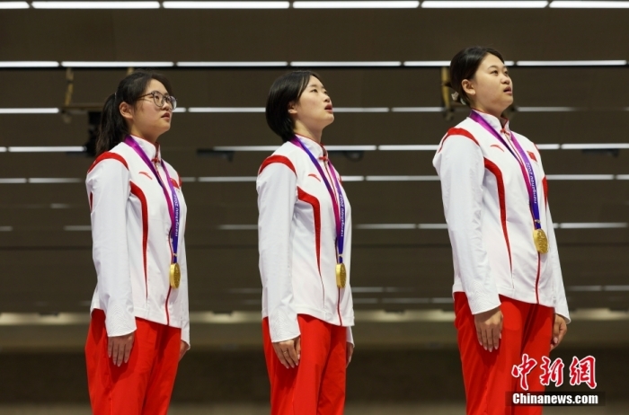 9月27日，杭州第19屆亞運(yùn)會射擊女子50米步槍3種姿勢團(tuán)體賽舉行，中國隊(duì)以1773的總分取得金牌。圖為中國選手韓佳予、夏思鈺、張瓊月(從左至右)在頒獎儀式上唱國歌。<a target='_blank' href='/'>中新社</a>記者 賈天勇 攝