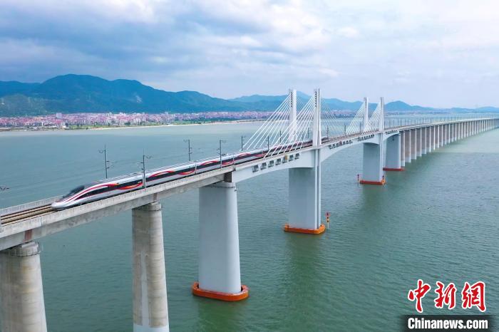 9月28日，復(fù)興號智能動車組行駛在福廈高鐵湄洲灣跨海大橋。歷經(jīng)6年多時間建設(shè)，全長277公里的福廈高鐵，穿越多處山脈，跨越多處海灣，將難上九重天的閩道與大海緊緊相連。李響攝