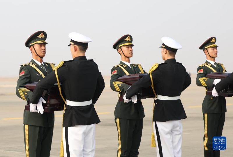 11月23日，在韓國(guó)仁川國(guó)際機(jī)場(chǎng)，中國(guó)人民解放軍禮兵（左）從韓方接過中國(guó)人民志愿軍烈士棺槨。（圖源：新華社）