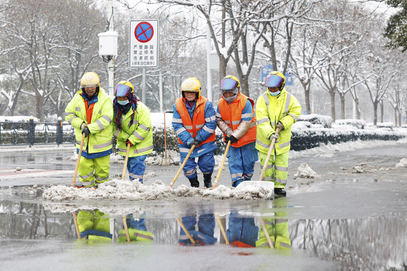 2月4日，在江蘇省宿遷市泗洪縣泗州大街，工作人員在清掃路面積雪。（圖源：新華社）