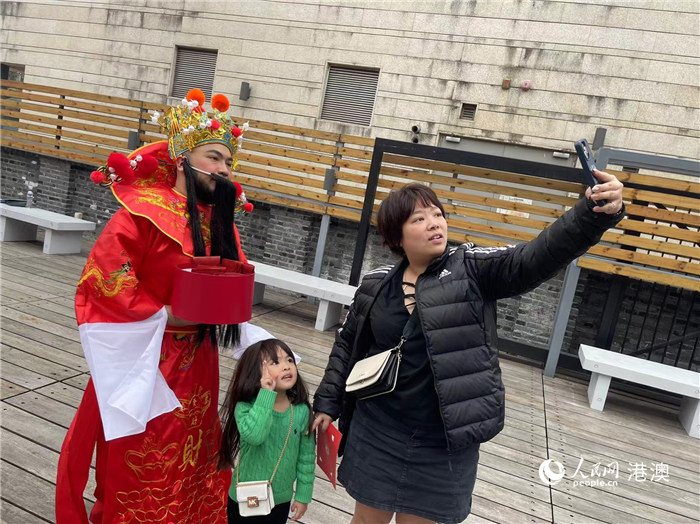圖為送出吉祥如意的財(cái)神與游客合影。人民網(wǎng)記者 富子梅攝
