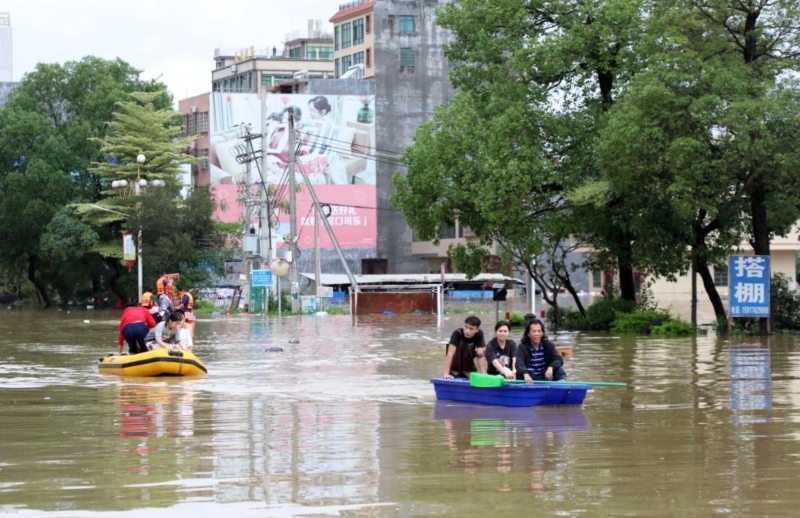 4月21日，廣東清遠(yuǎn)英德市浛洸鎮(zhèn)居民在積水的道路上乘船出行。新華社記者 黃國(guó)保 攝