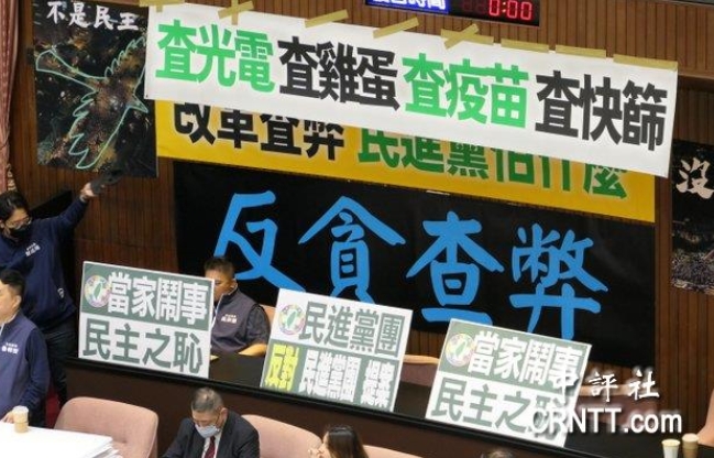 “立院”議場(chǎng)內(nèi)貼滿藍(lán)綠白的布條海報(bào)，上面寫著“查光電、查疫苗、查快篩”等字