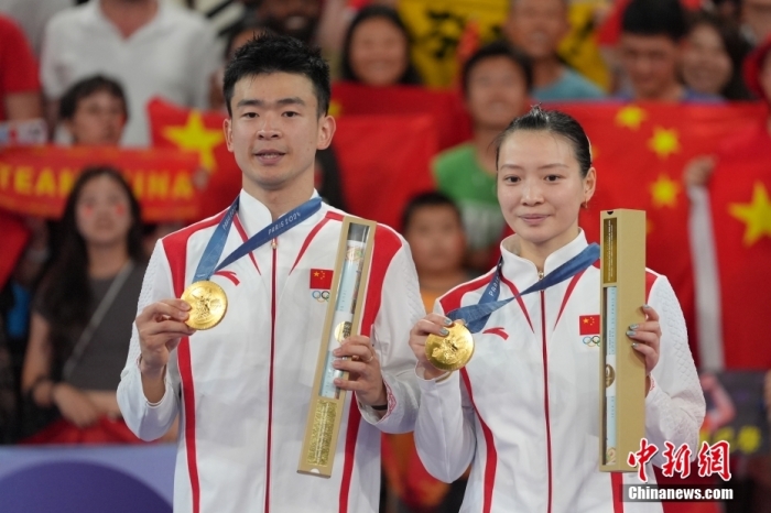 當(dāng)?shù)貢r間8月2日，在巴黎奧運會羽毛球混合雙打決賽中，中國組合鄭思維/黃雅瓊以2-0勝韓國組合金元昊/鄭娜銀，獲得金牌。圖為頒獎儀式上，鄭思維/黃雅瓊（右）展示金牌。<a target='_blank' href='/'>中新社</a>記者 趙文宇 攝