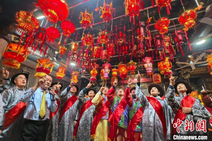 2月12日晚，閩臺東石燈俗活動(dòng)在福建省晉江市東石鎮(zhèn)嘉應(yīng)廟舉辦。圖為兩岸民眾同數(shù)一宮燈。中新網(wǎng)記者 孫虹 攝